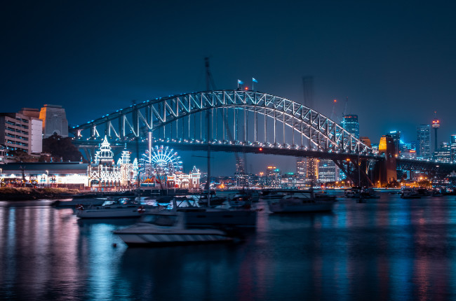 yachts sailing on the sydney harbour at night and it's beautiful