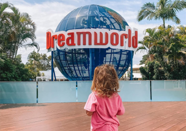 the back of a child looking at the dreamworld sign