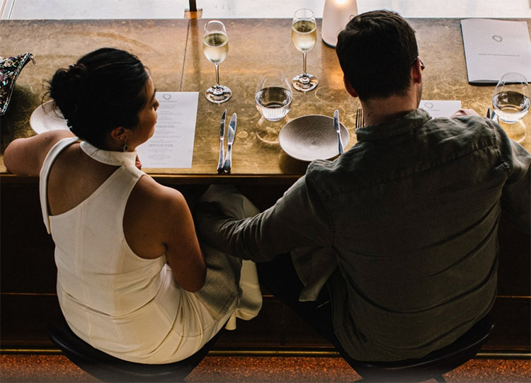 a couple sitting at a table in bennelong restaurant in sydney