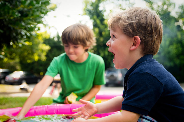 two kids sitting at the park having fun