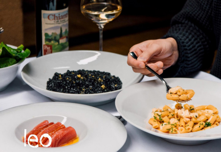 a person enjoying pasta and wine