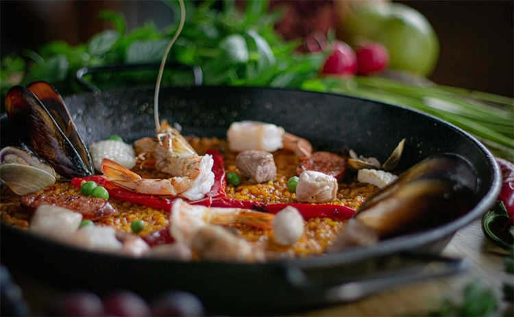 a black dish with paella inside